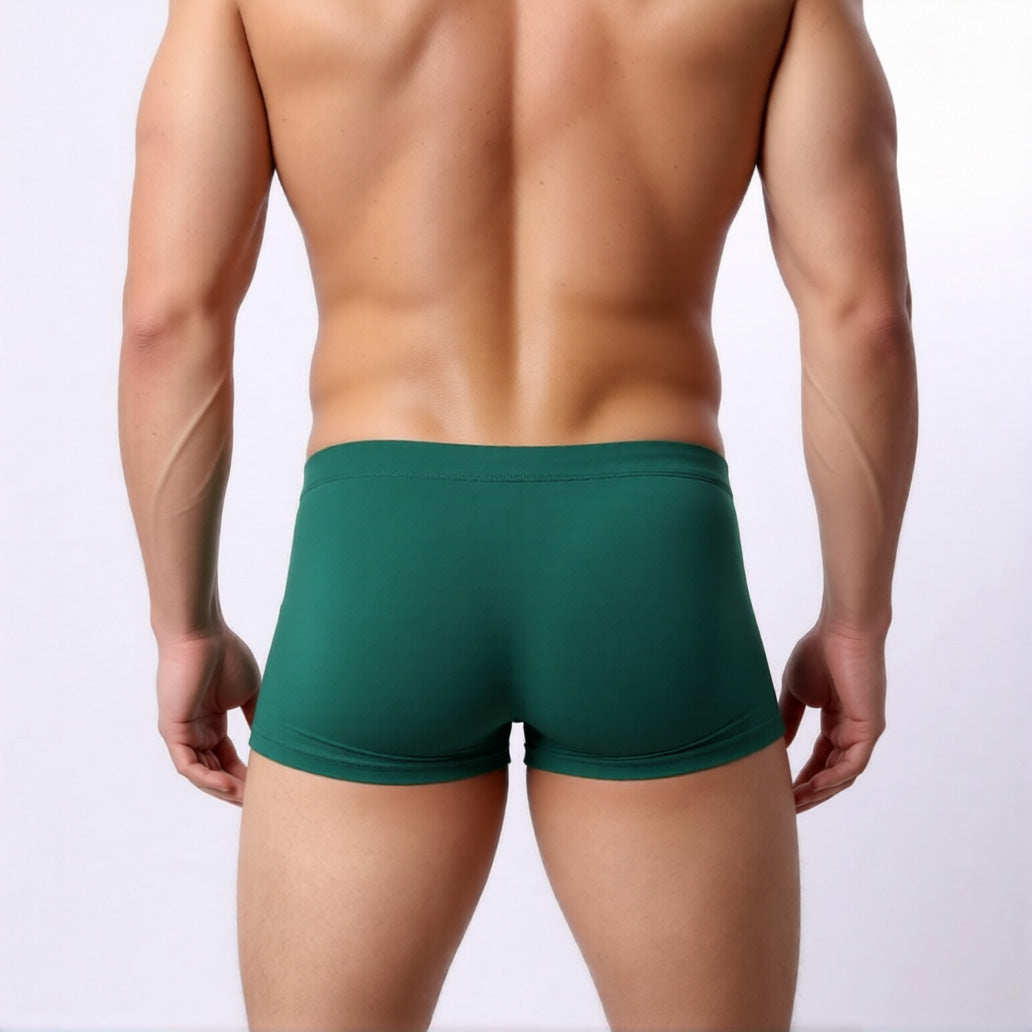 low rise men's swim trunks in green showing the square cut and athletic fit from the rear | color:green