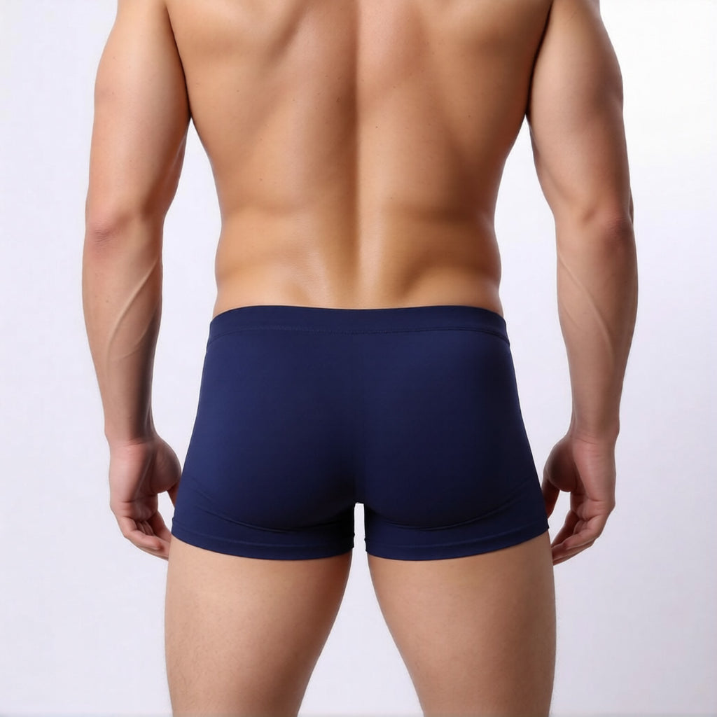 men's square cut swim trunks in navy showing the low rise and athletic fit from the rear| color:navy