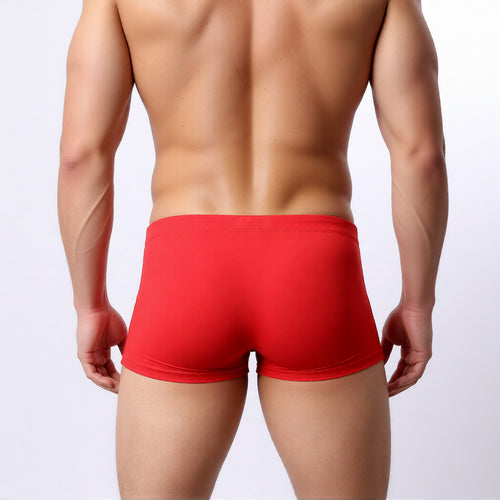 men's swim trunk in red showing the square cut and athletic, low-rise fit from the rear | color:red